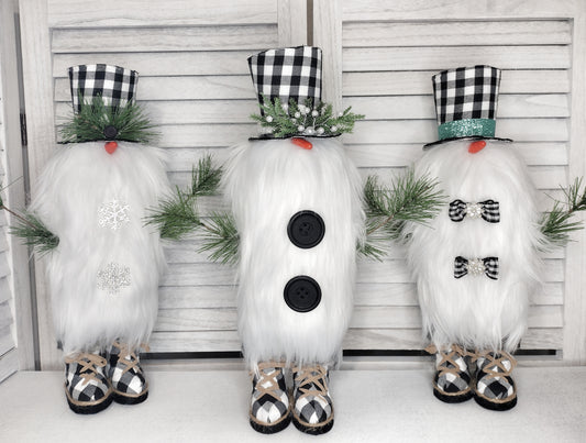 three snowmen gnomes with buffalo check top hate and snow boots